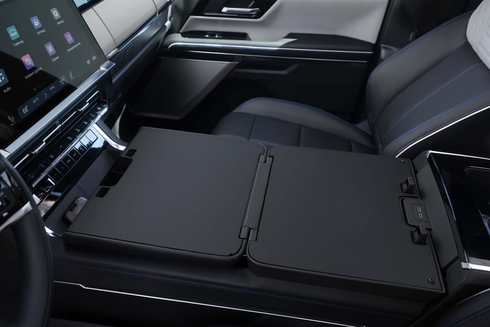 MultiPro center console on a 2027 GMC Sierra 1500 folded open into a flat work surface with USB-C ports
