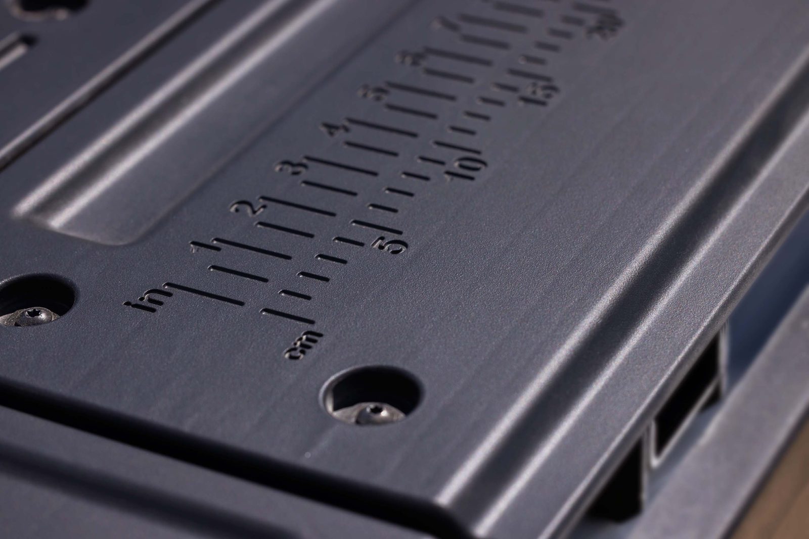 Close-up of the inch and centimeter ruler molded into the 2027 GMC Sierra 1500 MultiPro Tailgate
